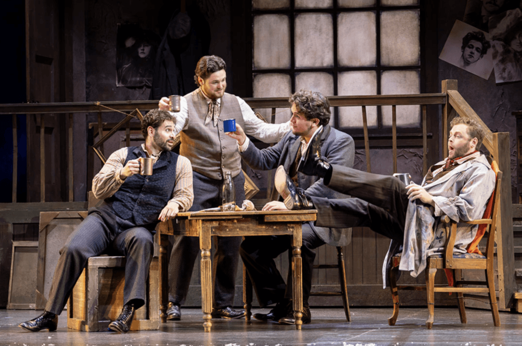 From left to right, Rodolfo (Jose Simerilla Romero), Schaunard (Jon Dirk Ross), Colline (Raúl Morales Velazco), and Marcello (Luke Sutliff) enjoy a final moment of brevity in Act IV. Photo by Don Ipock.